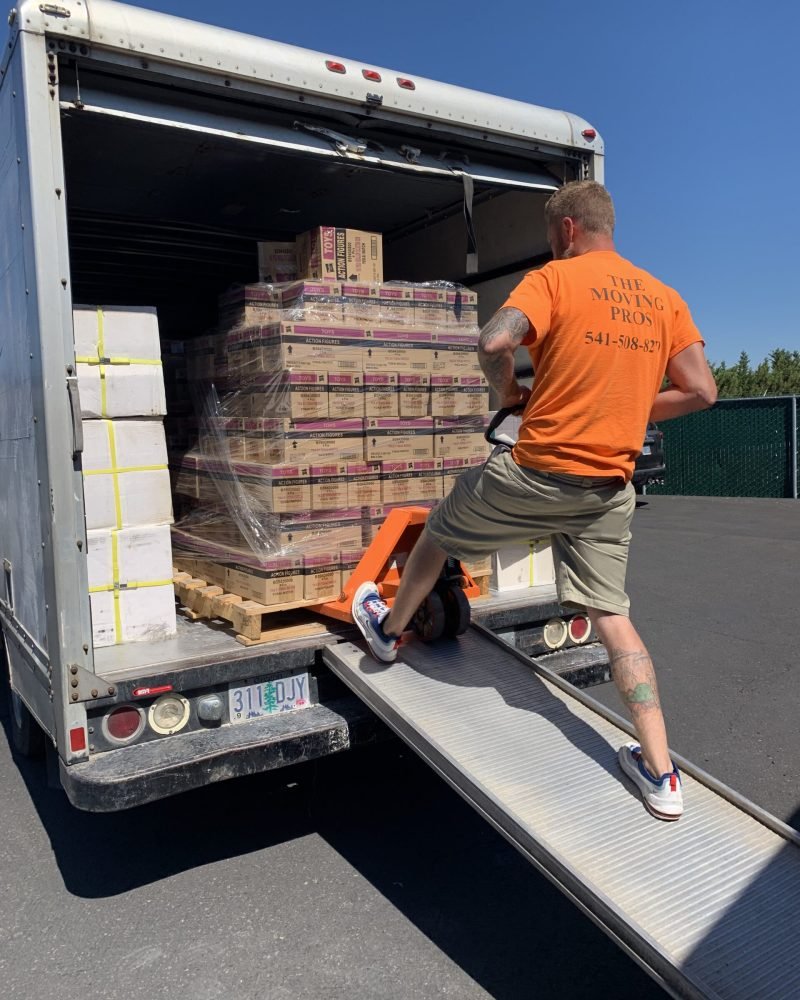 Moving professional unloading palletized boxes from a box truck using a pallet jack